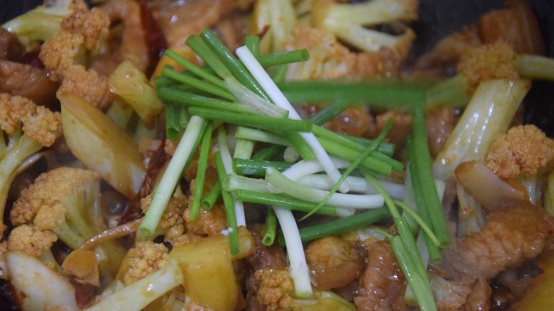 干锅菜花五花肉,倒入葱段,翻炒均匀待收汁即可关火出锅