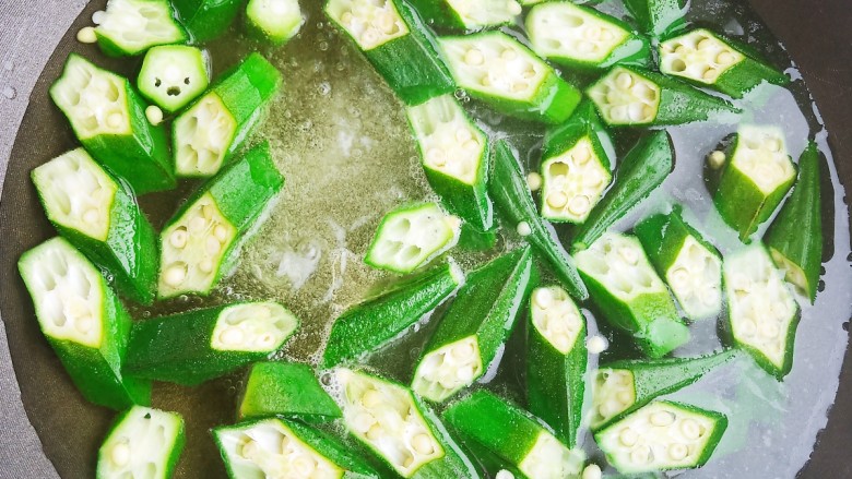 培根炒秋葵,锅中烧开水,加入适量食盐和食用油,加入秋葵焯水2分钟。