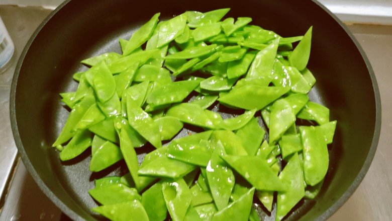 肉片炒荷兰豆,起油锅放入1汤匙食用油,油热后放入荷兰豆翻炒断生捞出备用。