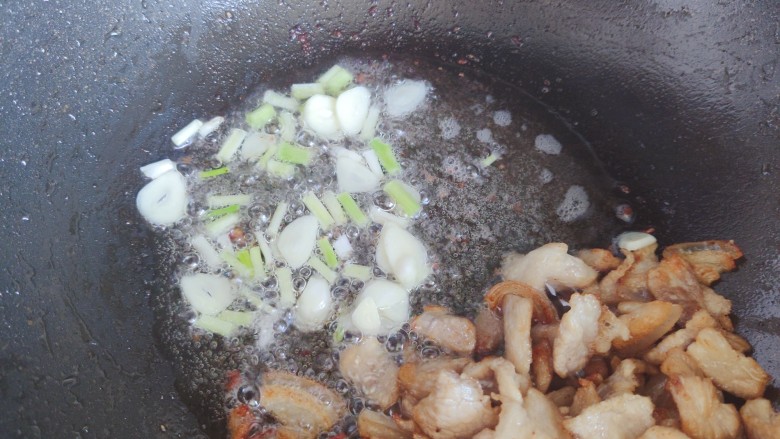 干锅菜花五花肉,下葱白和大蒜,炒香