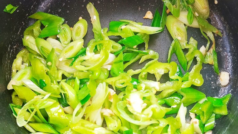 酸菜猪肠粉,锅中烧油,爆香蒜末和蒜苗。