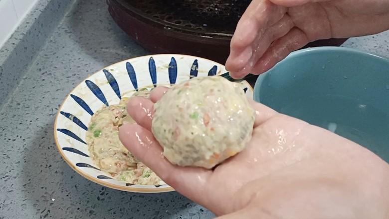 鲜虾蔬菜饼,手上沾点水,取适量馅团成圆形