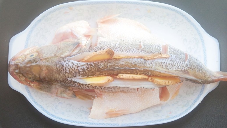 黄豆酱蒸鲈鱼,几分钟后,把腌料放在鱼肚子下面,水开上锅蒸10分钟。