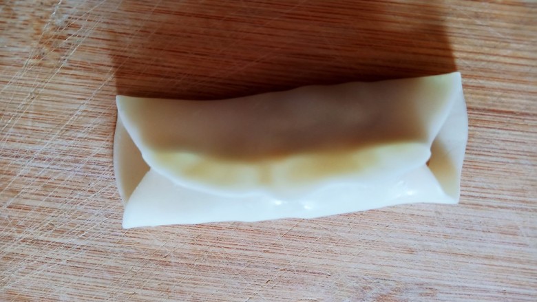 牛肉锅贴,将饺子皮对折捏住将馅儿料包在里面,两侧不要收口。