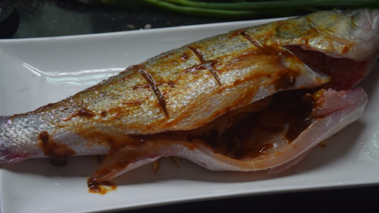 黄豆酱蒸鲈鱼,将剩下的姜丝塞入鱼肚中,再均匀地在鱼身抹上<a style='color:red;display:inline-block;' href='/shicai/ 4510'>黄豆酱</a>