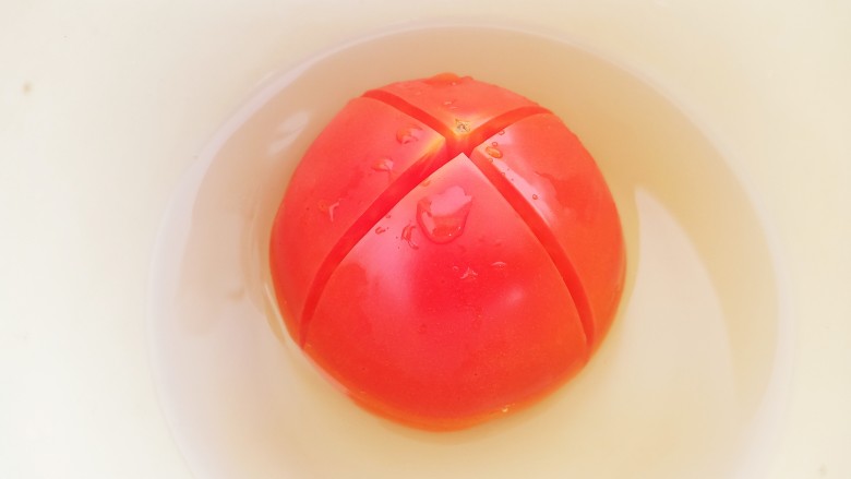 番茄鸡蛋面疙瘩汤,一个<a style='color:red;display:inline-block;' href='/shicai/ 3551'>西红柿</a>底部切十字花刀,用开水浸泡2分钟。