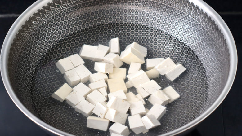 豆腐蛋花汤,锅中倒入适量的清水,加入少许盐,放入豆腐焯一下水,这样做出来的汤汁清澈干净,豆腐的口感更加细腻。