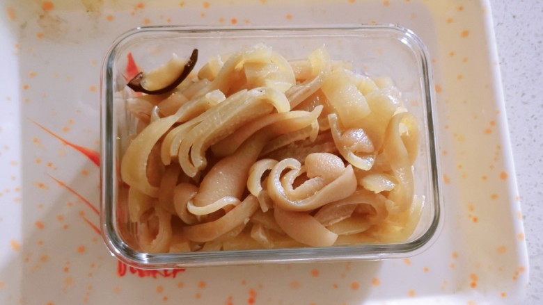泡椒猪皮,煮熟的肉皮切条状,放入玻璃容器中。