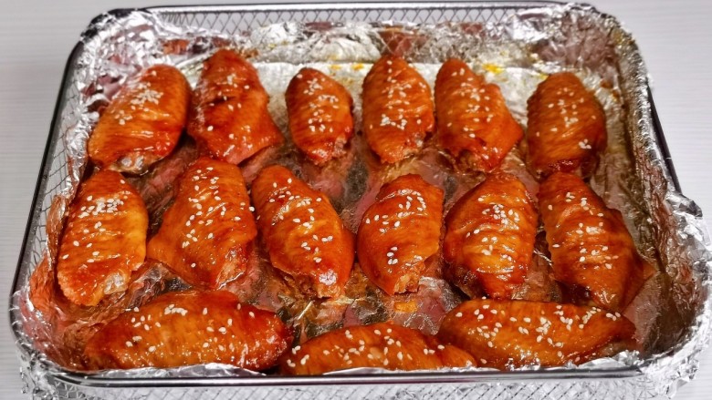 蒜香焖翅,烤15分时取出刷蜂蜜,撒上<a style='color:red;display:inline-block;' href='/shicai/ 678'>白芝麻</a>,再烤15分钟。