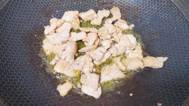 醋溜木须肉,炒锅内继续倒油烧热,下入腌好的里脊肉滑炒至变色,盛出备用。