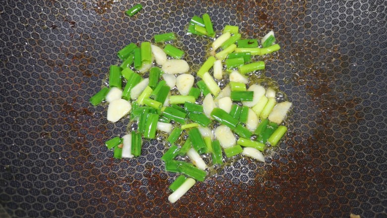 醋溜木须肉,锅底留余油烧热,下入葱蒜炒香。