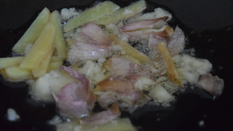 红烧鸭块,热锅凉油,倒入蒜蓉和姜片爆香