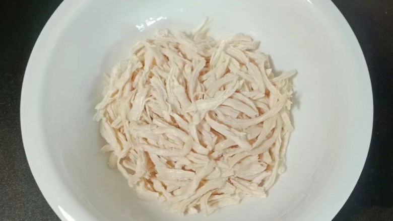 口水鸡丝,鸡胸肉捞出沥干水分,用手撕成细