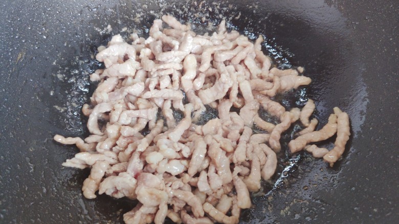 彩椒炒肉丝,起油锅,油热后下猪肉丝,翻炒至变色