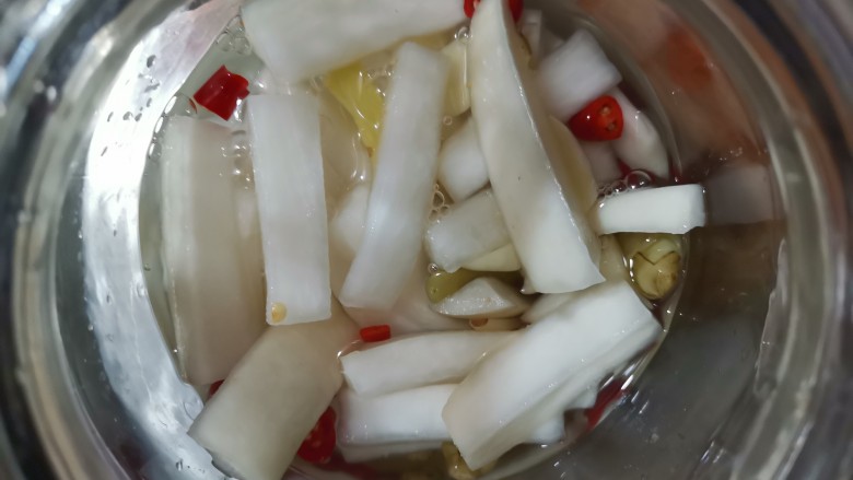 泡萝卜条,倒到干净的容器里面,再把刚刚煮好的醋水也倒进去