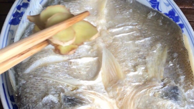 油泼鱼,鱼熟了,出锅装盘,拿掉姜片