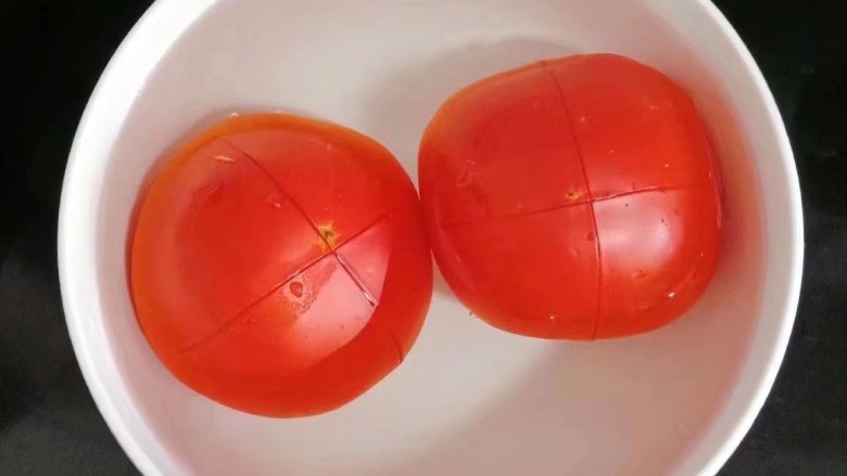 番茄烧茄子,<a style='color:red;display:inline-block;' href='/shicai/ 59'>番茄</a>顶部划十字刀,放入热水中浸泡