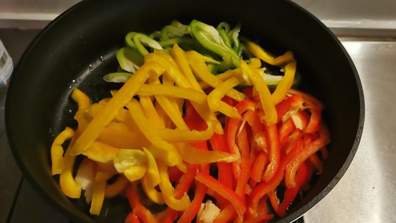 彩椒炒肉丝,起油锅放入2汤匙食用油,油热后放入彩椒翻炒断生。