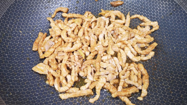 彩椒炒肉丝,炒锅内倒适量的食用油烧热,下入腌好的肉丝,滑炒至变色盛出备用。