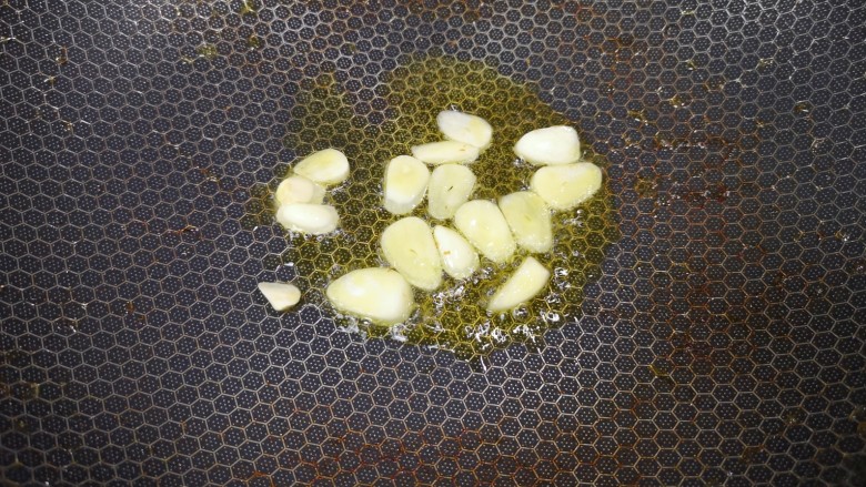 彩椒炒肉丝,锅里继续倒油烧热,下入蒜片炒香。