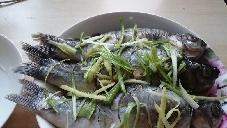 油泼鱼,葱姜切丝,放在鱼身