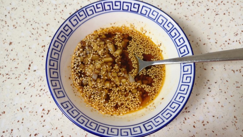 口水鸡丝,炒锅内倒适量的<a style='color:red;display:inline-block;' href='/shicai/ 848'>菜籽油</a>烧热,浇在蒜末上面激出香味。