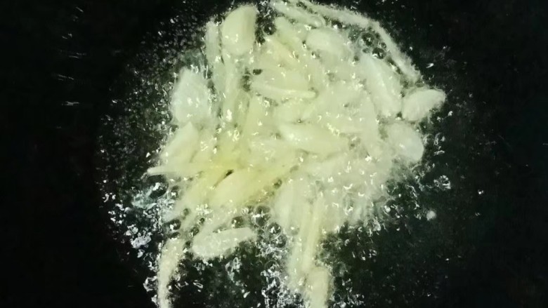 西兰花炒口蘑,热锅下油,放入大蒜和姜丝爆香