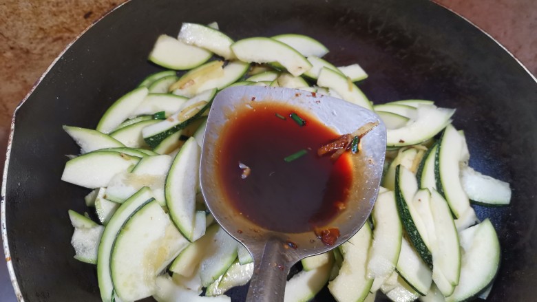 嫩南瓜炒肉丝,加入一勺生抽,翻炒均匀