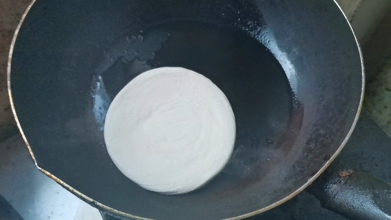 家常肉夹馍,锅烧热,加入适量油,下入饼坯小火烙