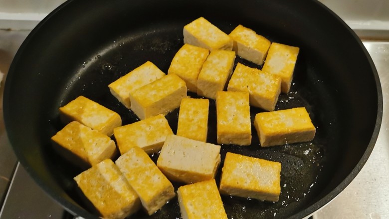 酸辣豆腐,平底锅放入食用油,油热后放入豆腐块煎至两面金黄。