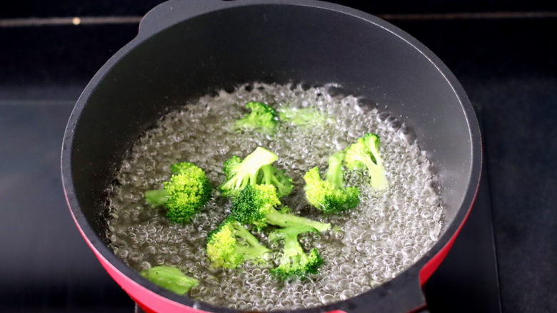 夏日藜麦甜虾时蔬饭团,锅中倒入适量的清水,加入少许盐和几滴油烧开,放入<a style='color:red;display:inline-block;' href='/shicai/ 119'>西兰花</a>焯至断生变色捞出备用。