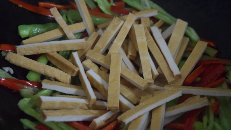 双椒豆干,倒入豆干,翻炒一分钟