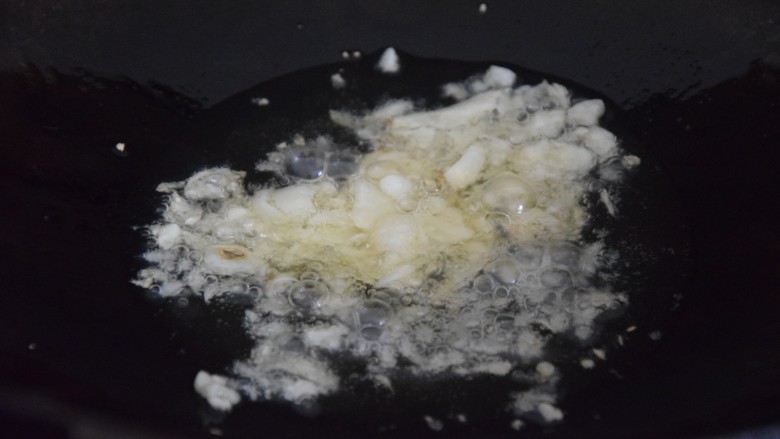 双椒豆干,热锅凉油,倒入蒜末炒香