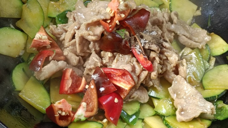 嫩南瓜炒肉丝,倒入瘦肉,红辣椒翻炒均匀