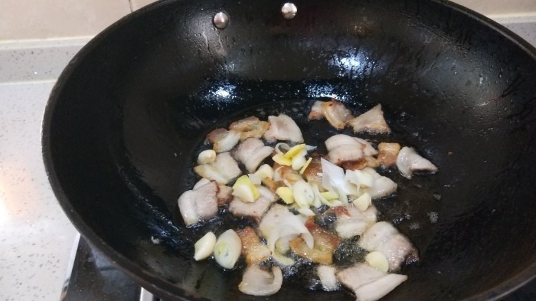 双椒豆干,适量油,倒入肉片儿,倒入葱姜蒜炒香。