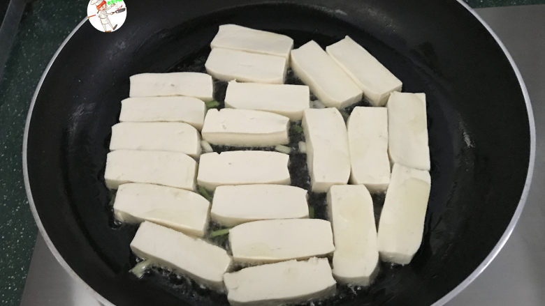 酸辣豆腐,平底锅烧热,倒入2汤匙食用油,先下入葱白爆香,再把切好的豆腐放进去