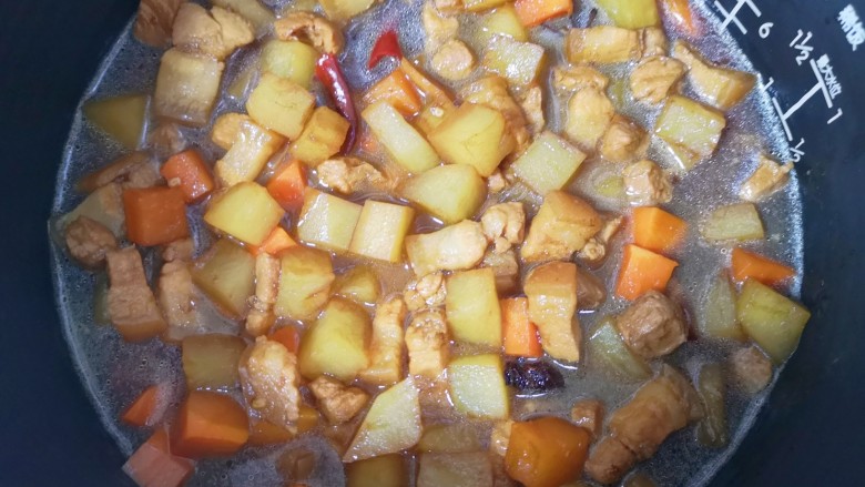 五花肉焖饭,倒入炒好的五花肉和蔬菜,按电饭锅的“煮饭”键启动。