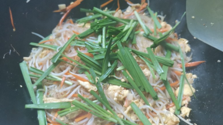 韭菜豆芽炒粉丝,下入韭菜段,翻炒均匀即可出锅