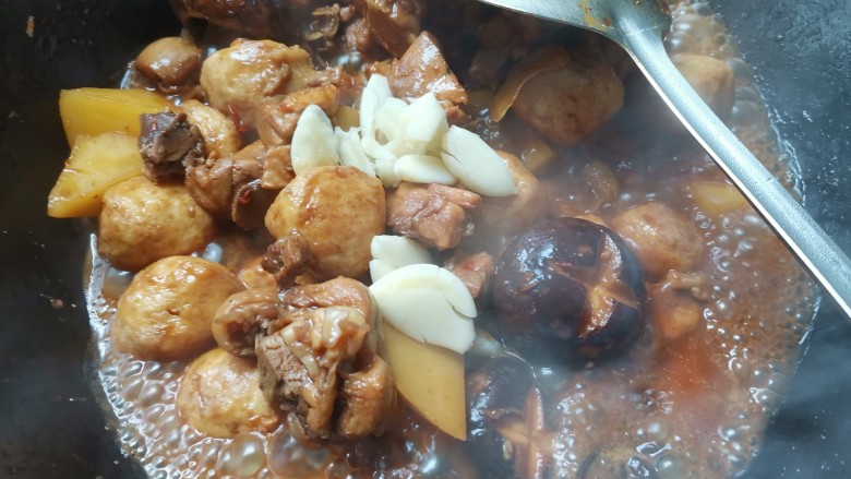 土豆香菇焖鸡,炖至汤收干,加入大蒜翻炒均匀即可出锅
