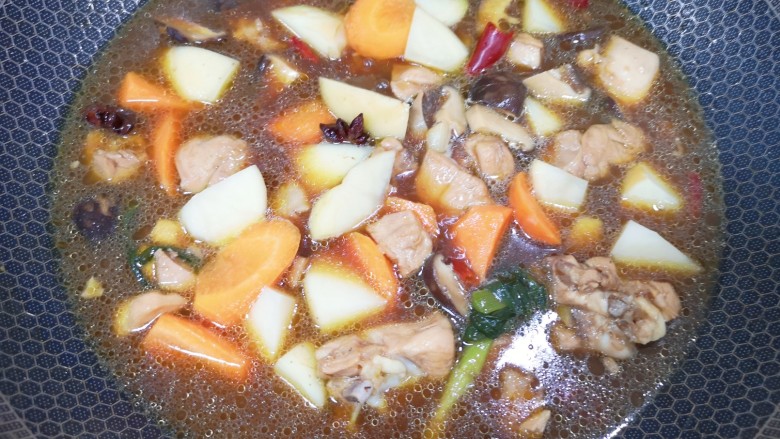 土豆香菇焖鸡,20分钟以后下入土豆和胡萝卜块翻炒均匀,中火煮8分钟。