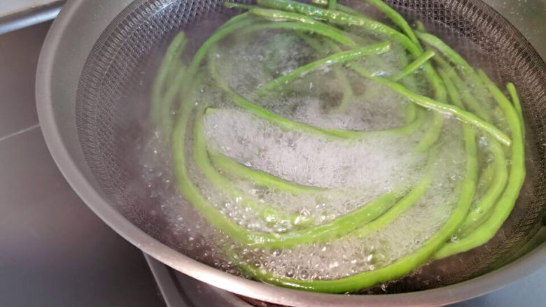 酱香鸡佐麻花豇豆,豇豆入锅焯熟,水锅中要加盐、油,才能保持翠绿