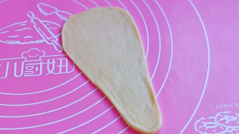肉松牛角包,再用擀面杖擀成长舌状,上宽下窄,如图。
