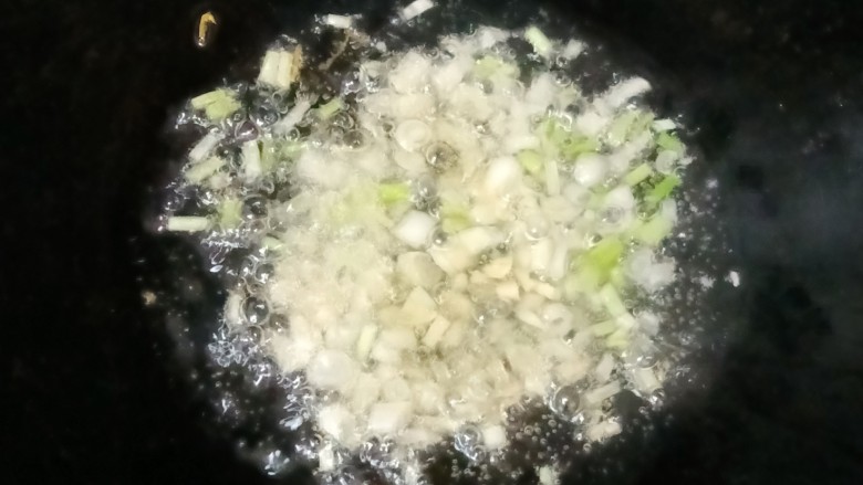 酸汤肉片,热锅下油,放入蒜末和葱白爆香