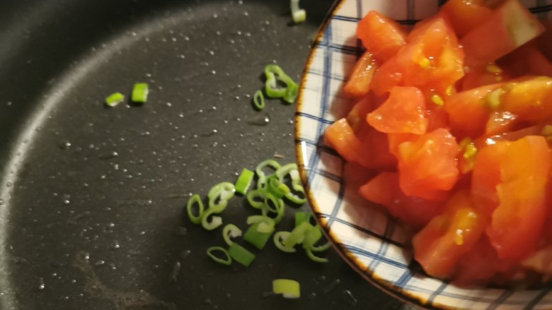黄瓜烧豆腐,锅中留下底油继续加热,放入葱碎炒出香味,放入番茄翻炒。
