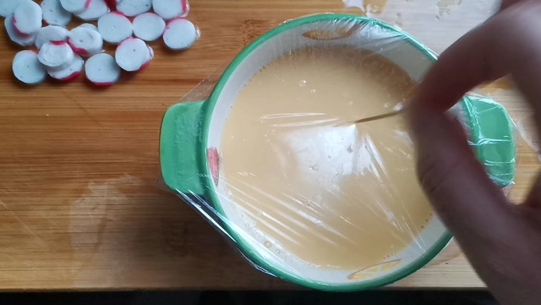 蟹棒蒸蛋,封上保鲜膜,扎几个小孔