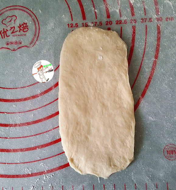 肉松牛角包,取一份面团,擀成长舌形,翻面后并压簿底边,再自上向下卷成卷