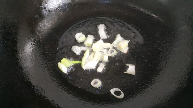 酸汤肉片,锅中放入适量食物油,爆香葱白