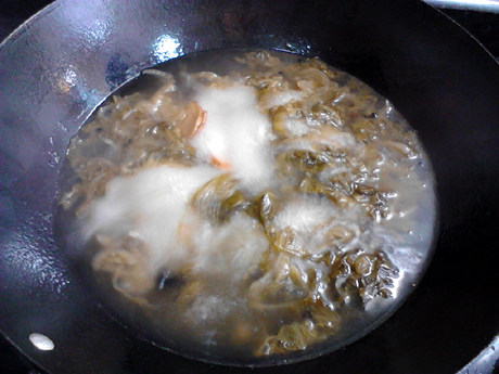 酸汤肉片,大火煮沸后转中火,继续煮约半小时,至酸菜变软。