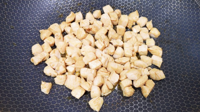 酱爆双丁,炒锅内倒适量的食用油烧热,下入腌好的鸡胸肉翻炒至变色,盛出备用。