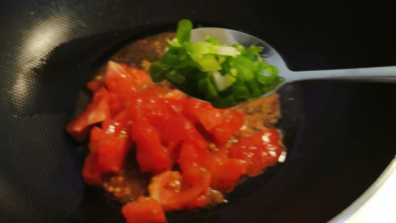 番茄海鲜饭,锅中留下底油继续加热,放入番茄翻炒,放入香葱增香。